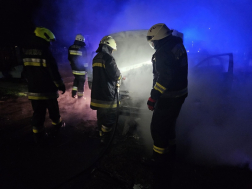 A tűzoltók oltják az égő autó motorterét