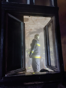 A tűzoltó az épületet vizsgálja